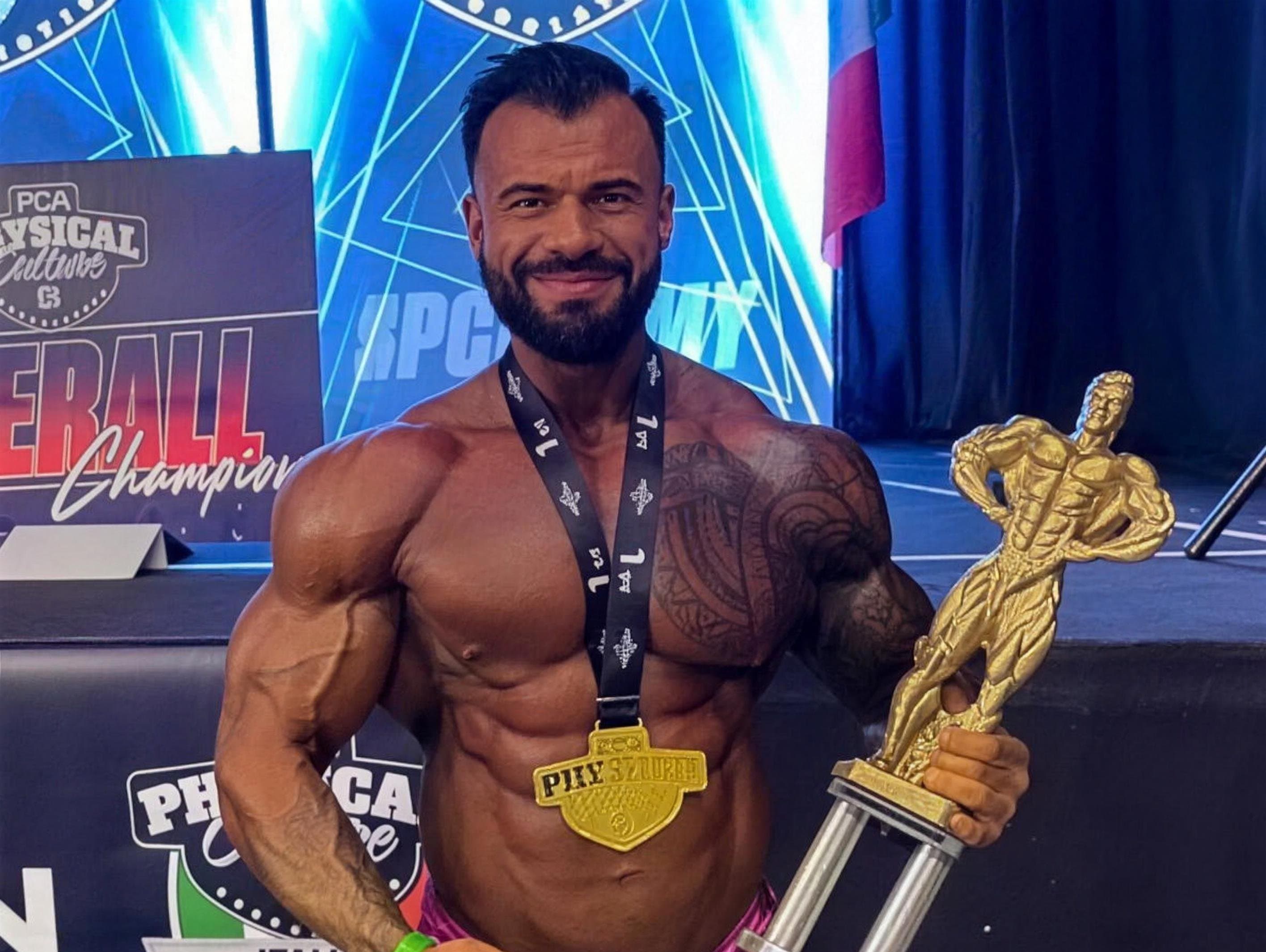 Jakub Wolar ze złotem i pucharem PCA Physical Culture Italia